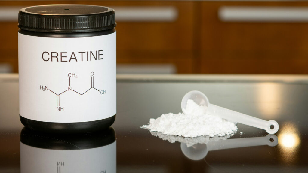 Pot de créatine en poudre accompagné d’une dosette