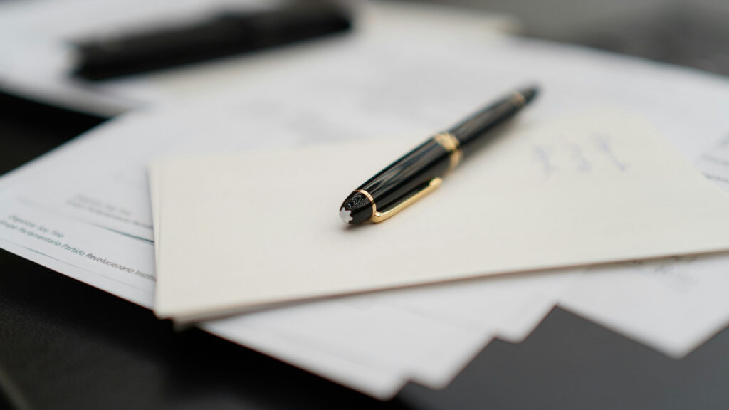 Un stylo posé sur des documents administratifs.